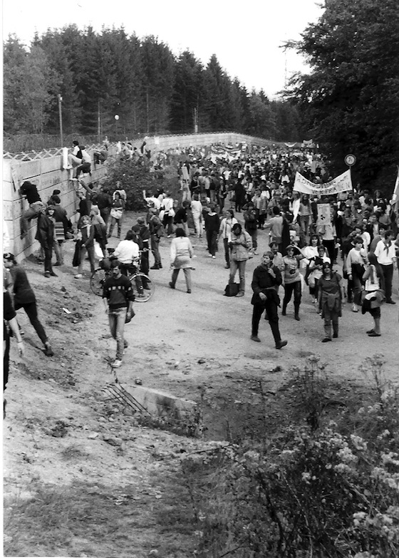 Viele Menschen auf einem Feldweg am Waldrand
