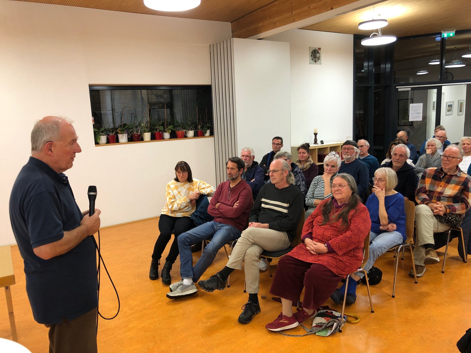 Andreas Zumach spricht mit Mikrofon vor dem Publikum im Saal